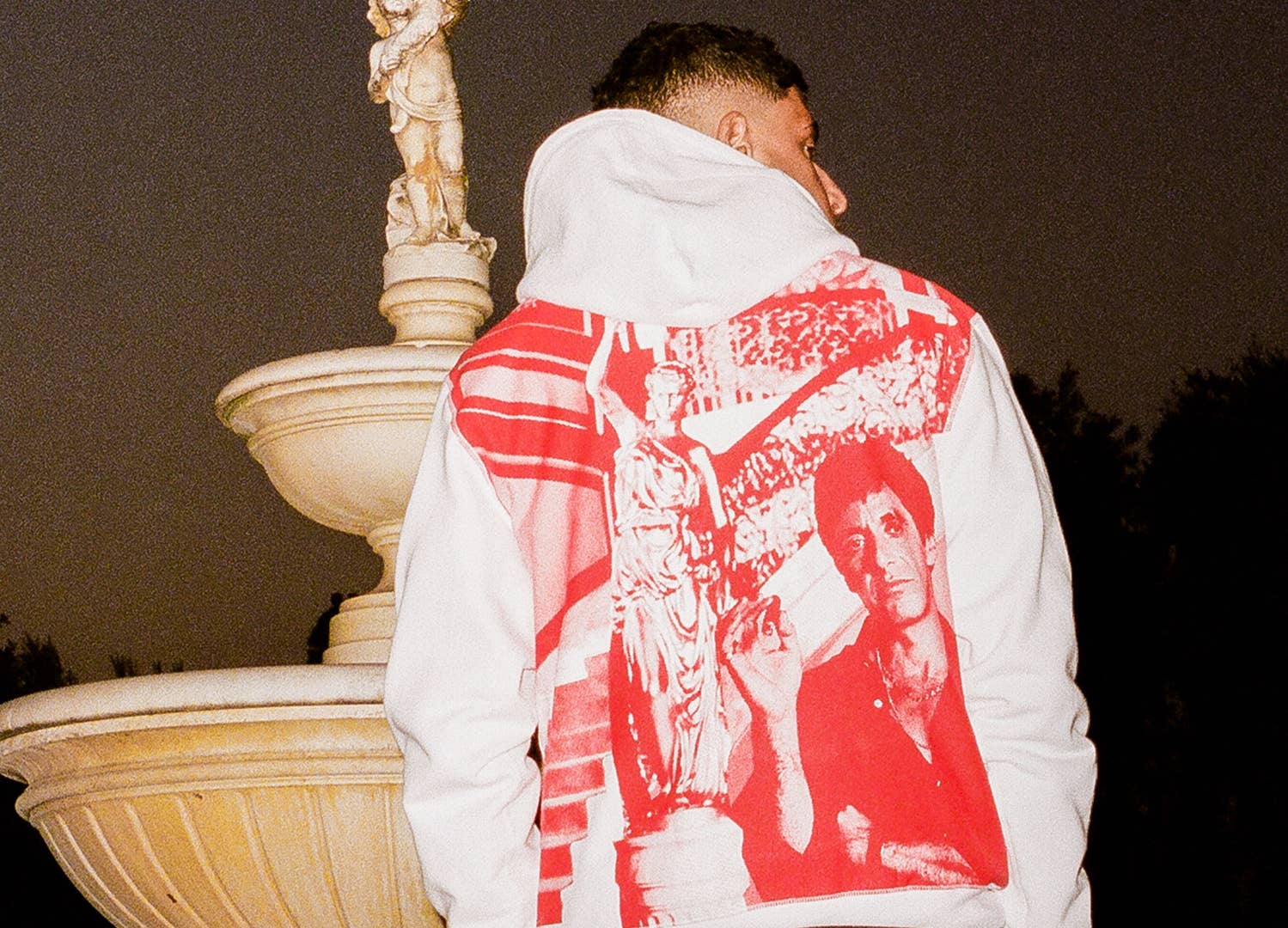 Model wearing a white hoodie with Tony Montana (Al Pacino) pictured in red.