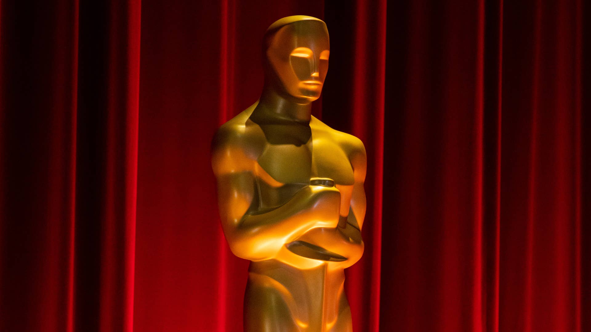 Oscars trophy is pictured in front of red background