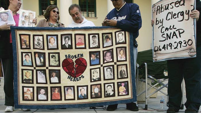 Alleged sexual abuse victims stand during a vigil.