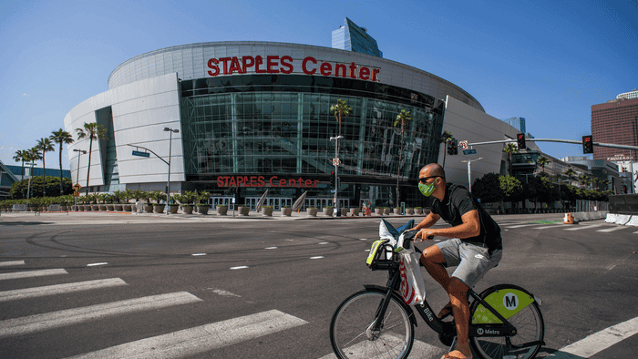 A man bikes past the Staples Center during the COVID 19 pandemic.