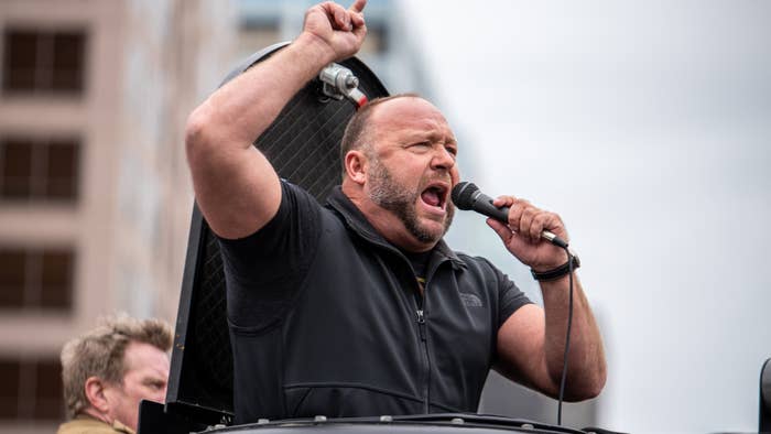 Alex Jones is pictured pointing to the sky
