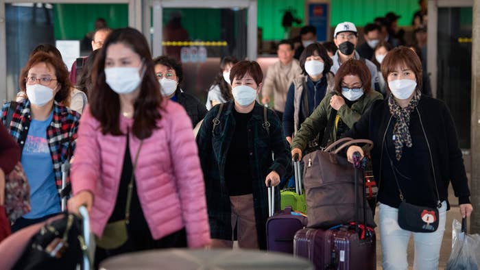 Passengers getting off a flight with face masks on.