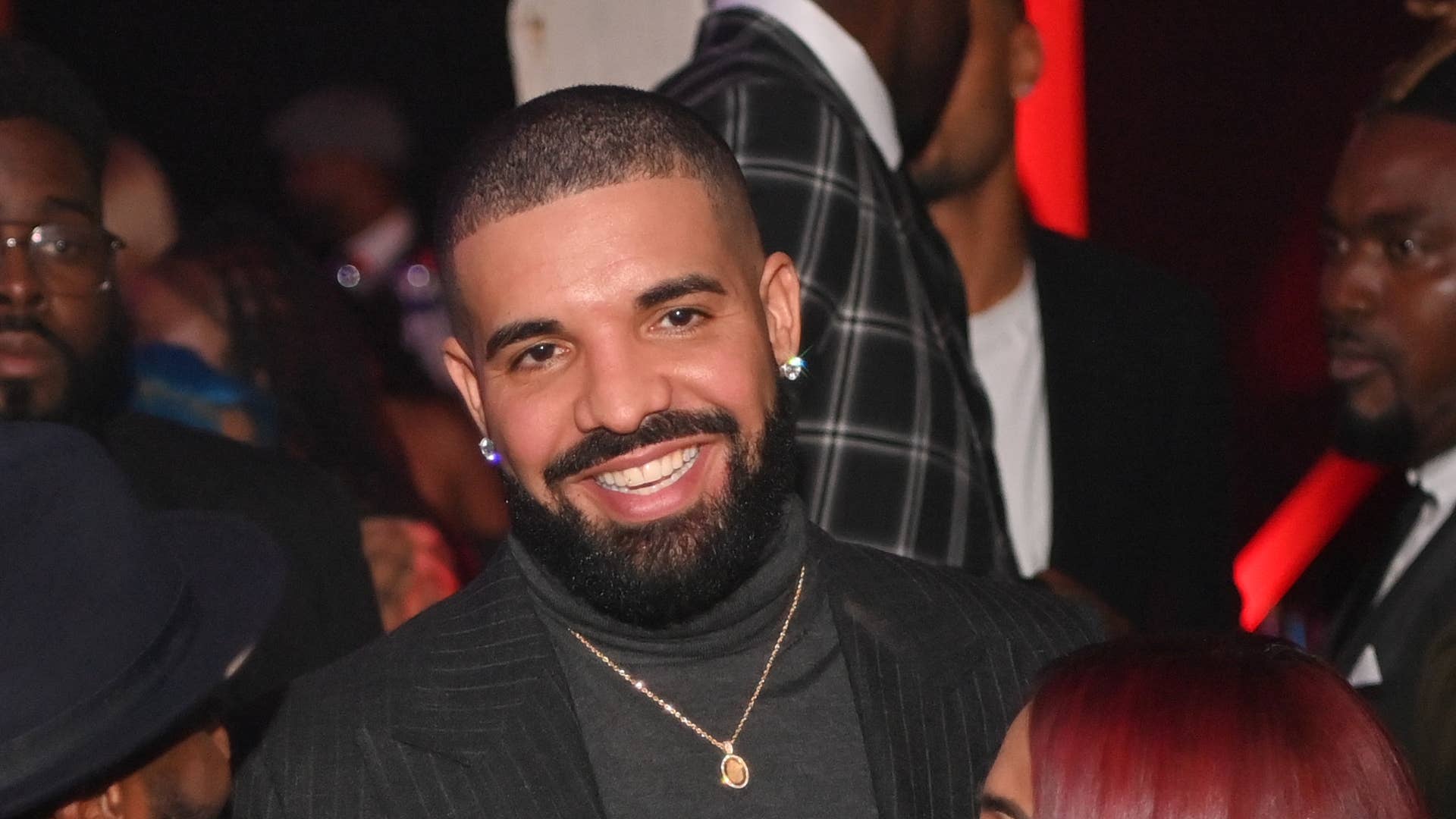Drake is seen at an event wearing a turtleneck