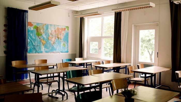 Desks and chairs arranged in classroom at high school