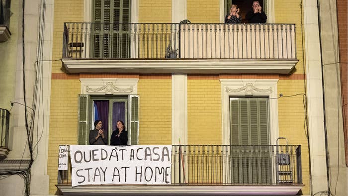 Spanish people sit on balconies during COVID 19 lockdown