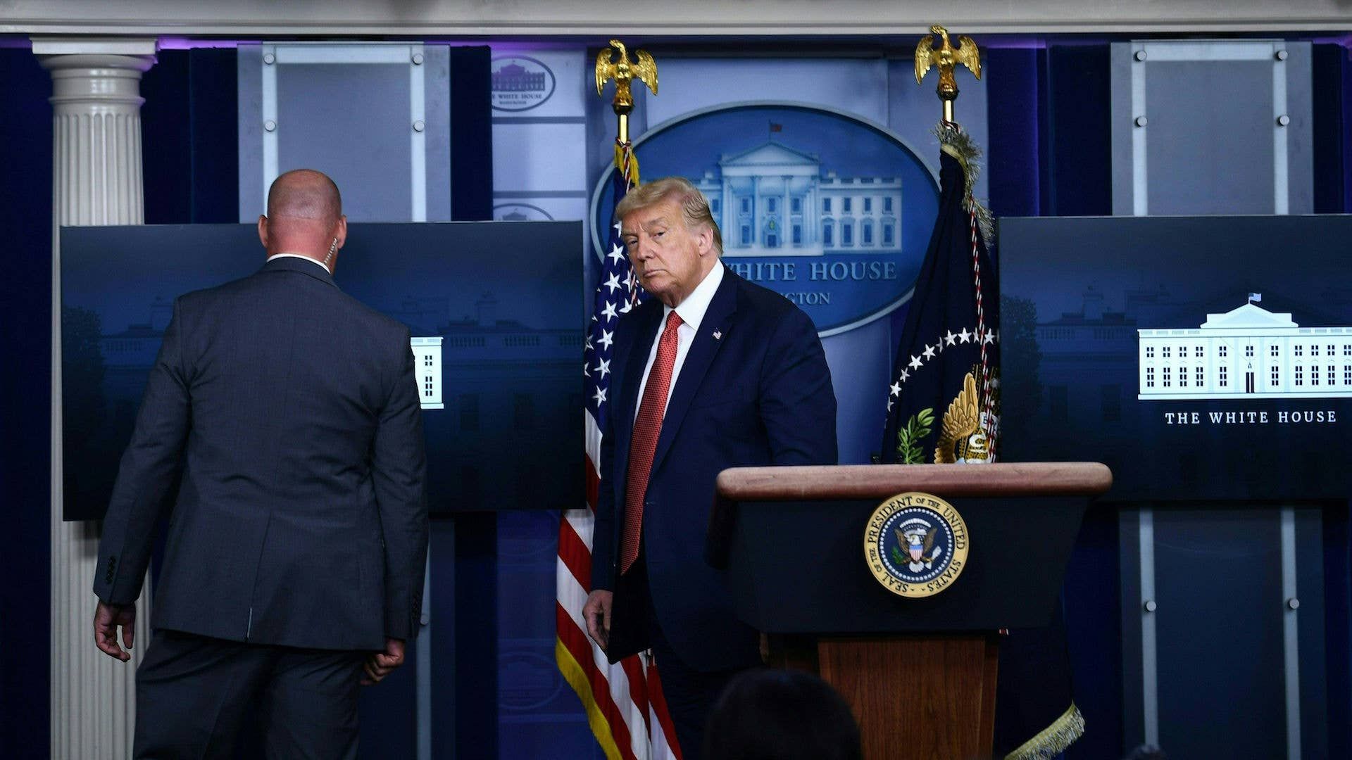Donald Trump is being removed by secret service member from the Brady Briefing Room of White House.