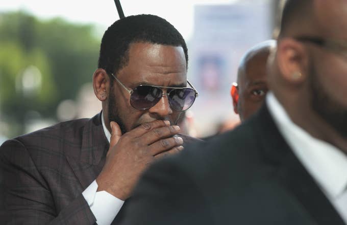 R&amp;B singer R. Kelly covers his mouth as he speaks