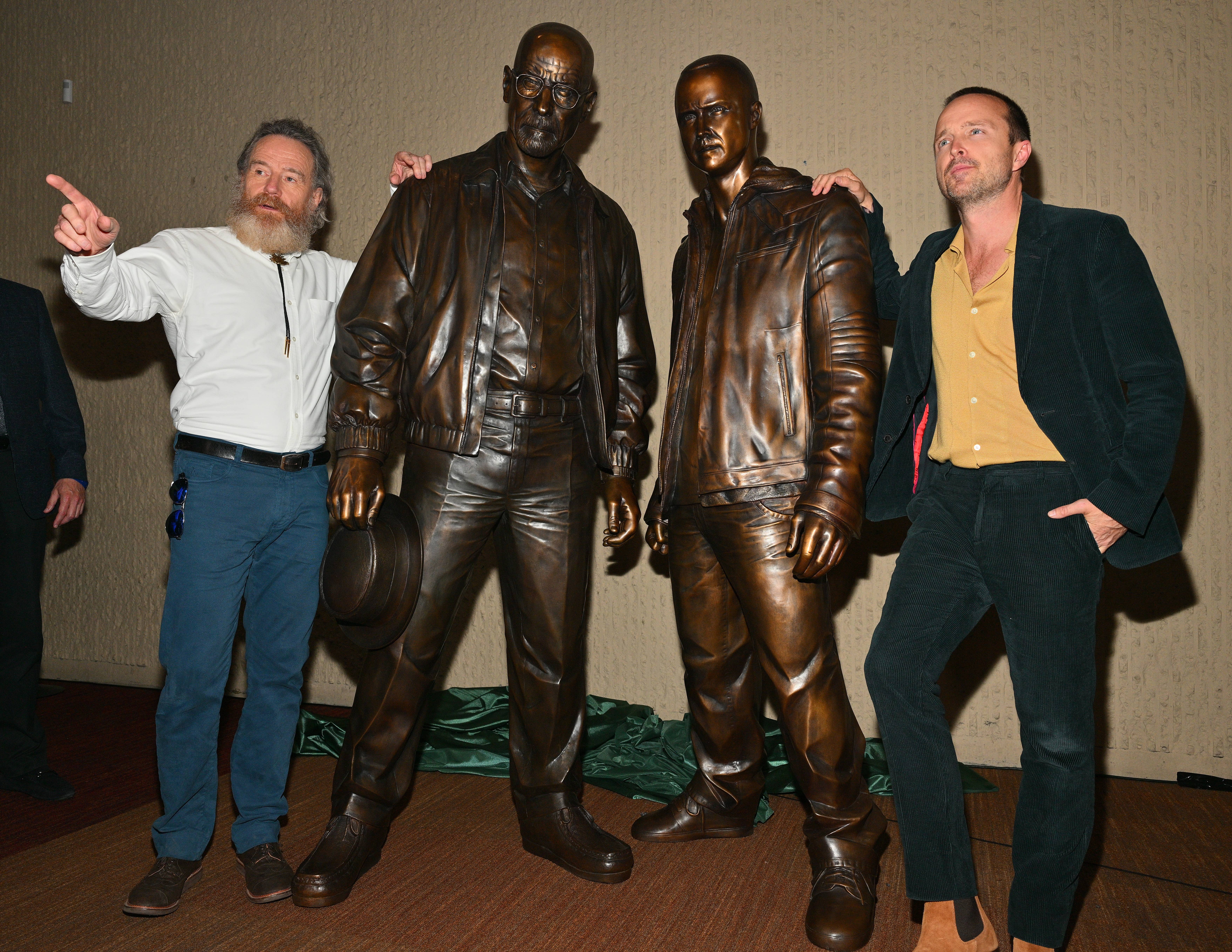 breaking bad stars standing next to statues