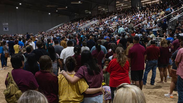 Members of the community gather at a vigil for the 21 people killed