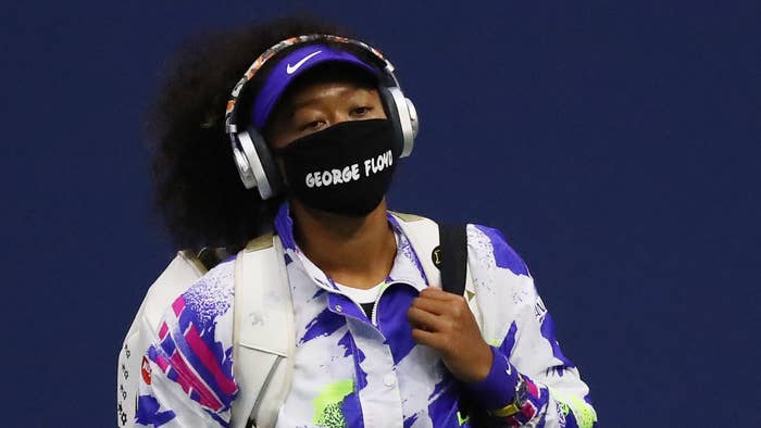 Naomi Osaka walks in wearing a mask with the name of George Floyd on it.