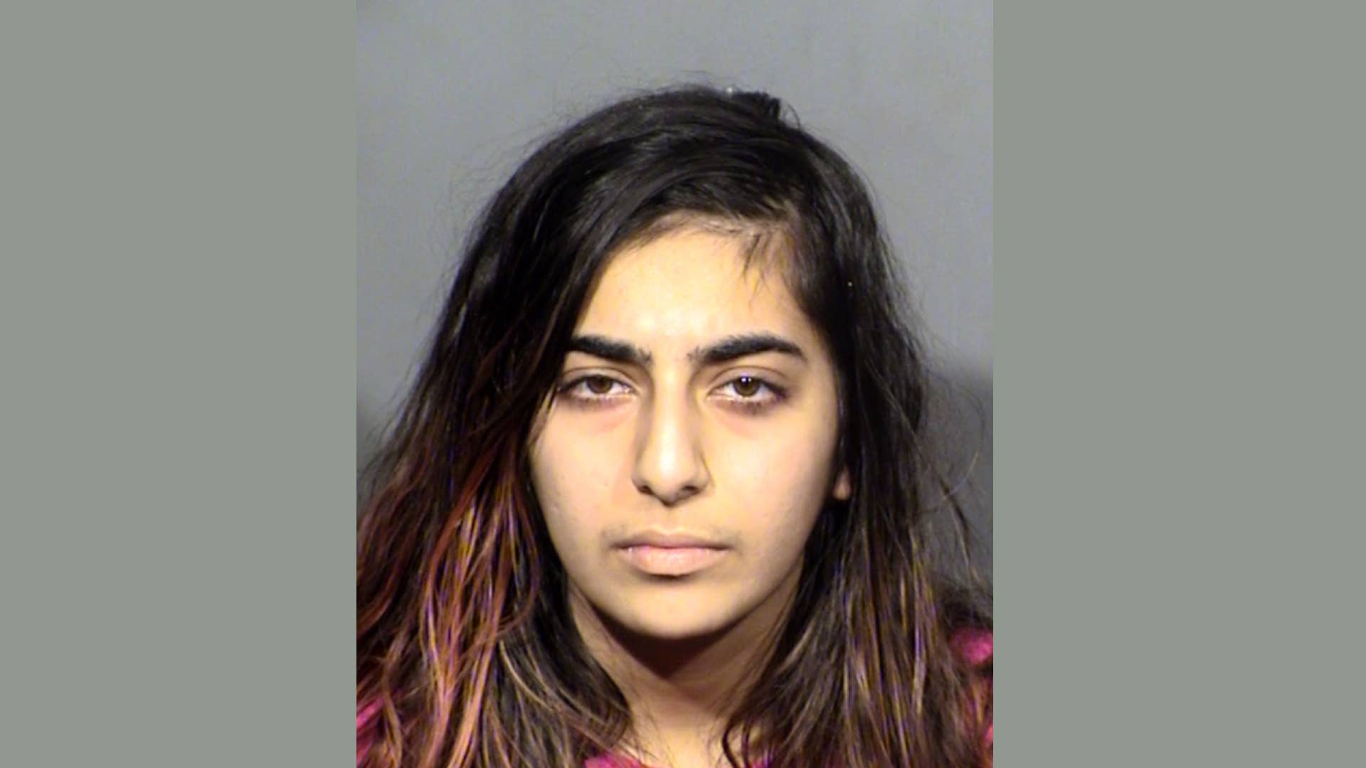 A woman is pictured in a mugshot over a stabbing incident