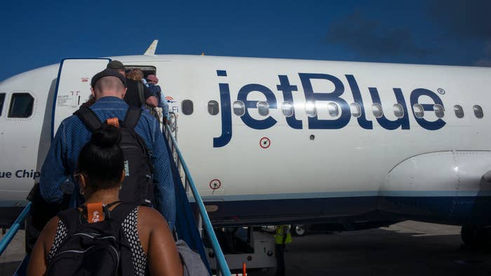 Passengers departing on a JetBlue Airways flight to New York walk up a ramp.