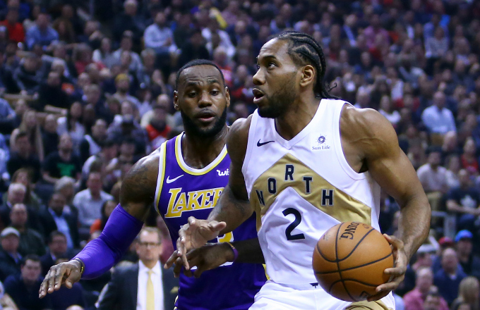 Kawhi Leonard #2 of the Toronto Raptors dribbles the ball as LeBron James