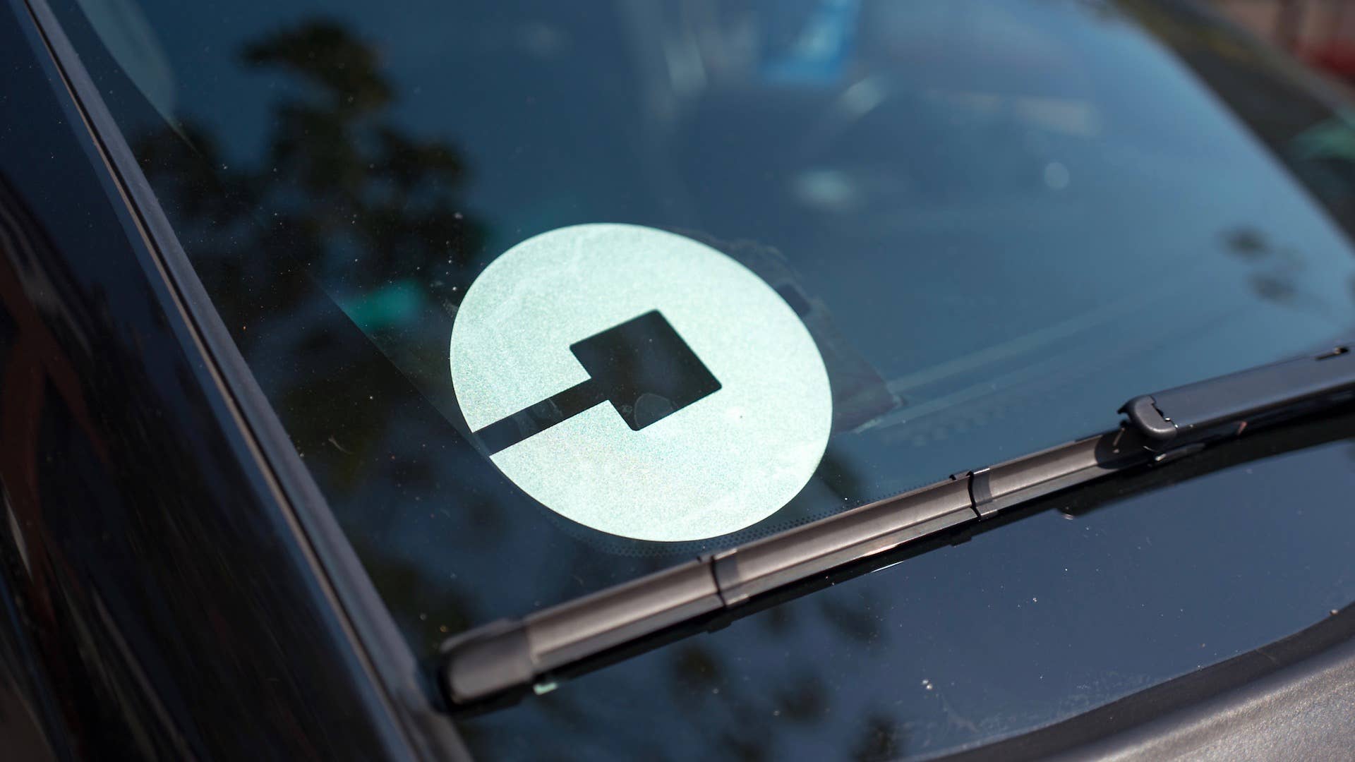 Logo for car sharing company Uber on the passenger side windshield