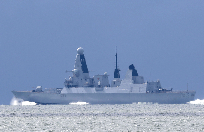 The HMS Defender passes the Isle of Wight after leaving Portsmouth Harbour.