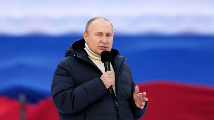 Vladimir Putin is pictured holding a microphone