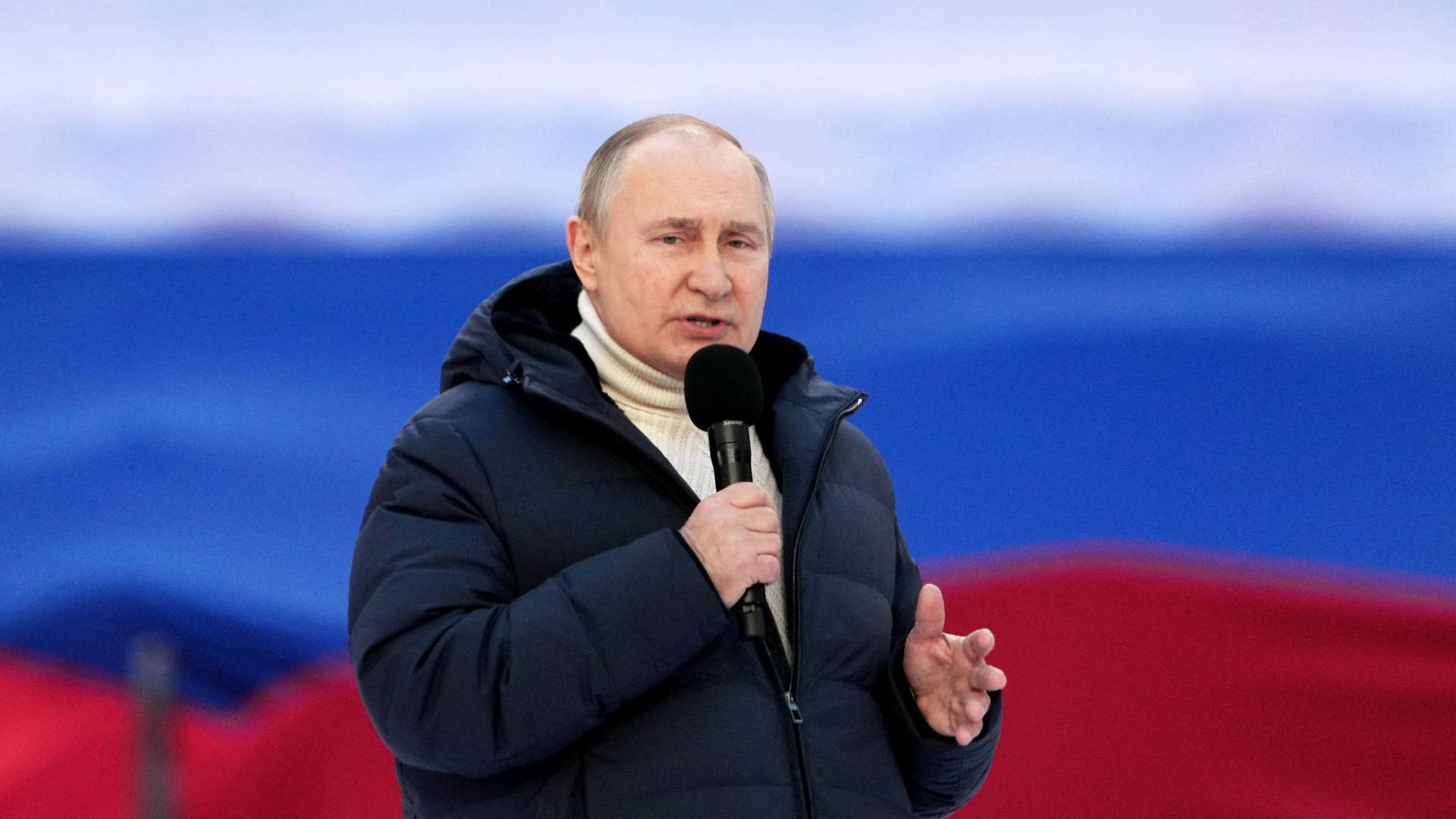 Vladimir Putin is pictured holding a microphone
