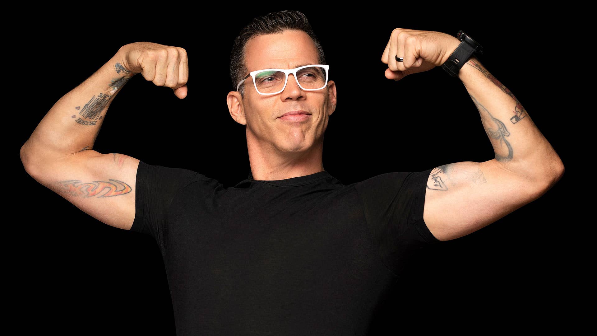 Steve-O poses in front of a black background