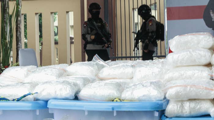Police guard bags of seized methamphetamine.