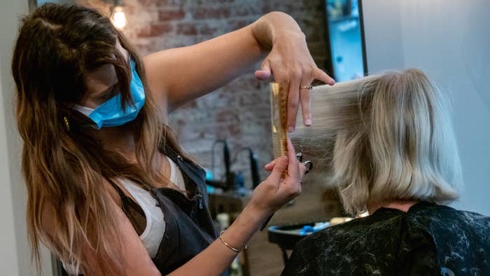 A cosmetologist styles a customers hair at Parlour Salon