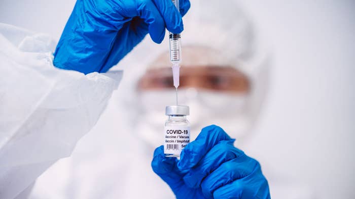 Doctor filling syringe with COVID-19 vaccine.