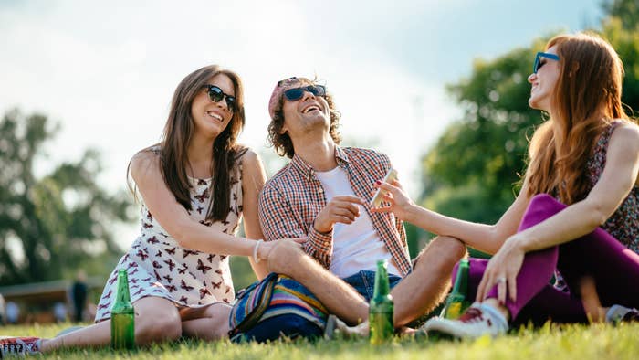 Three friends enjoying beer in a park