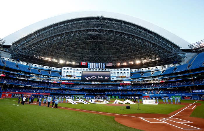 The Toronto Blue Jays line up behind a &#x27;Home&#x27; sign to commemorate their first home game in Toronto this season prior to a MLB game against the Kansas City Royals at Rogers Centre on July 30, 2021 in Toronto, Canada.