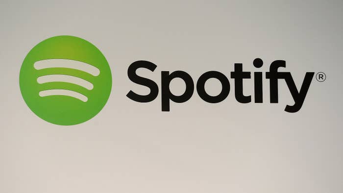 A Spotify logo is seen as founder and CEO Daniel Ek addresses a press conference in New York.