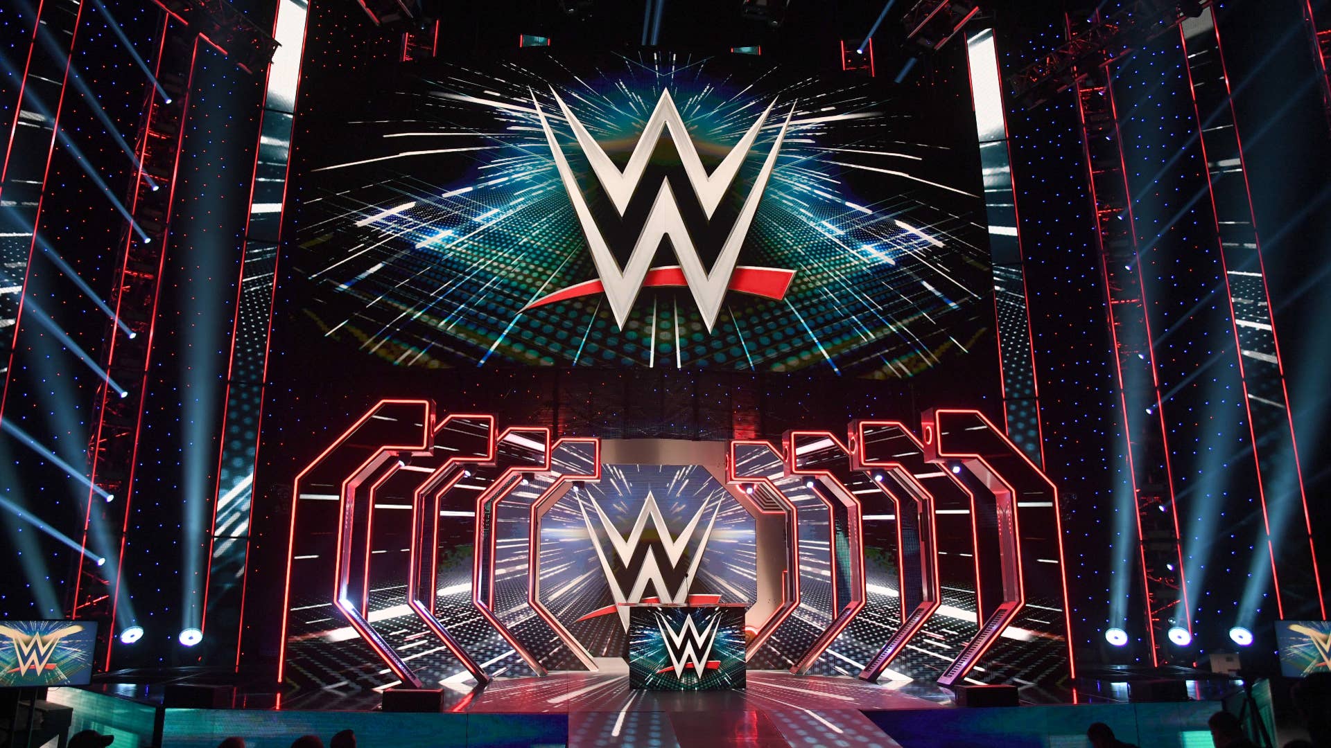 WWE logos are shown on screens before a WWE news conference.