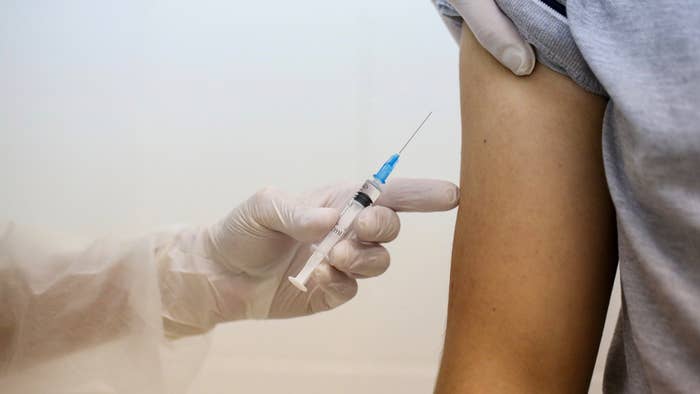 A heath worker prepares to inject the Covid-19 trial vaccine into a patient