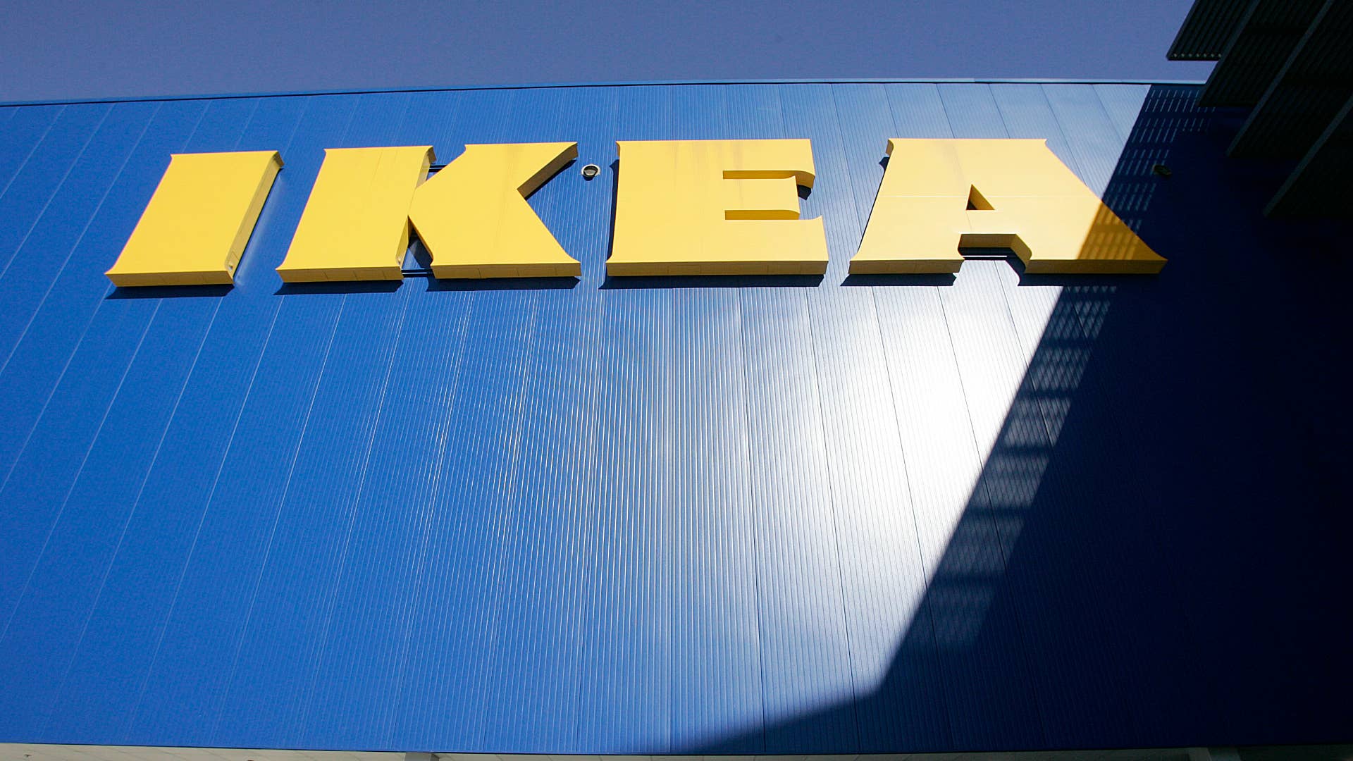 An IKEA sign hangs on a the side of an Ikea store.