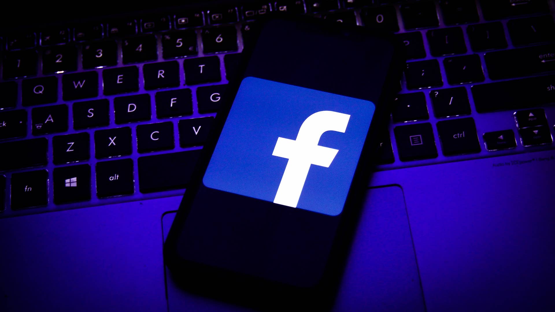 Logo of Facebook displayed on a smartphone screen and keyboard.