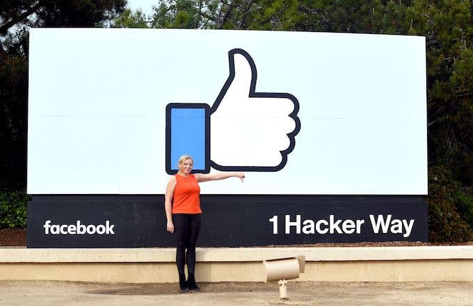 Woman making thumbs down sign outside Facebook headquarters.