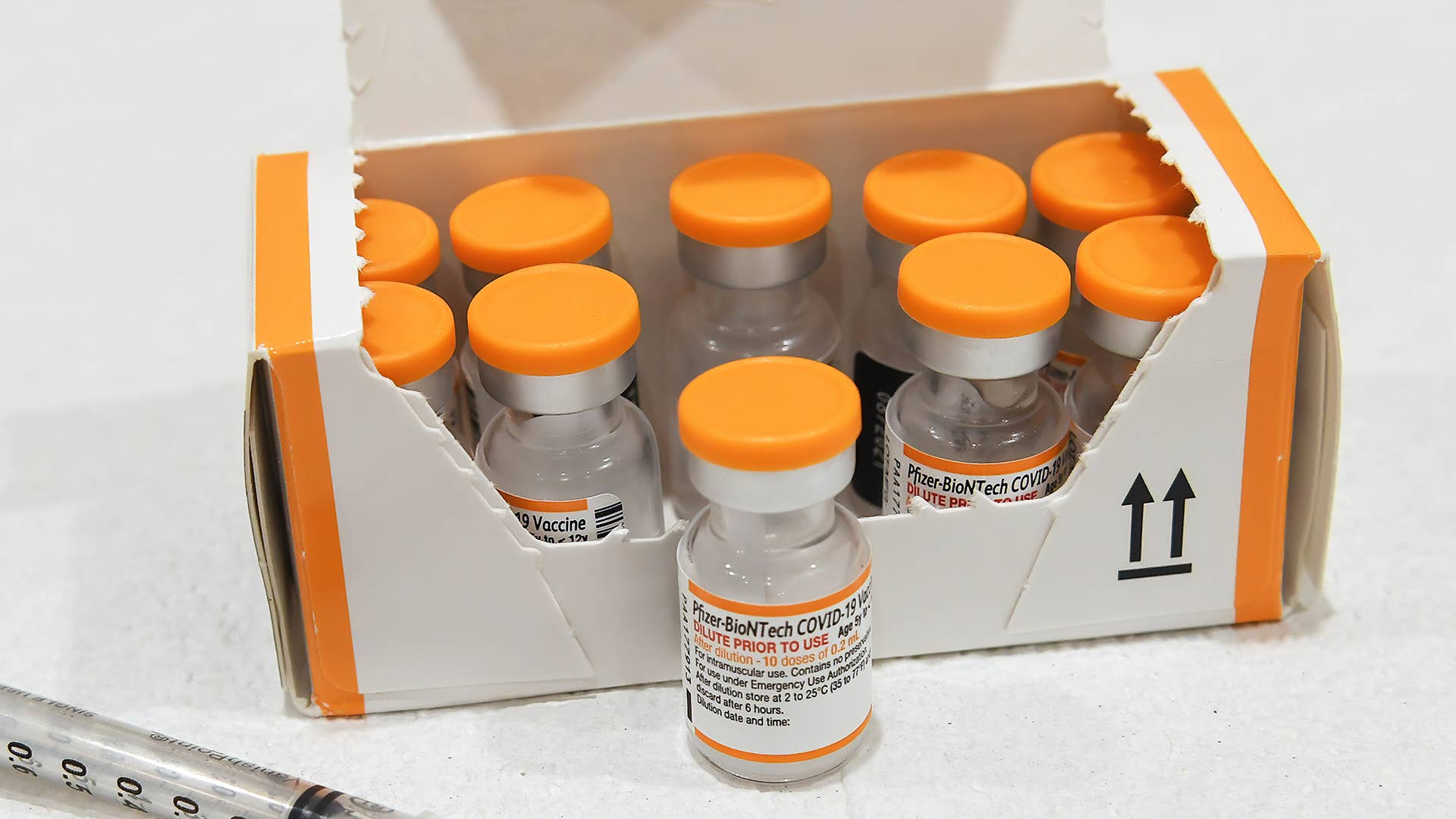 A box of orange capped doses of the Pfizer COVID-19 vaccine