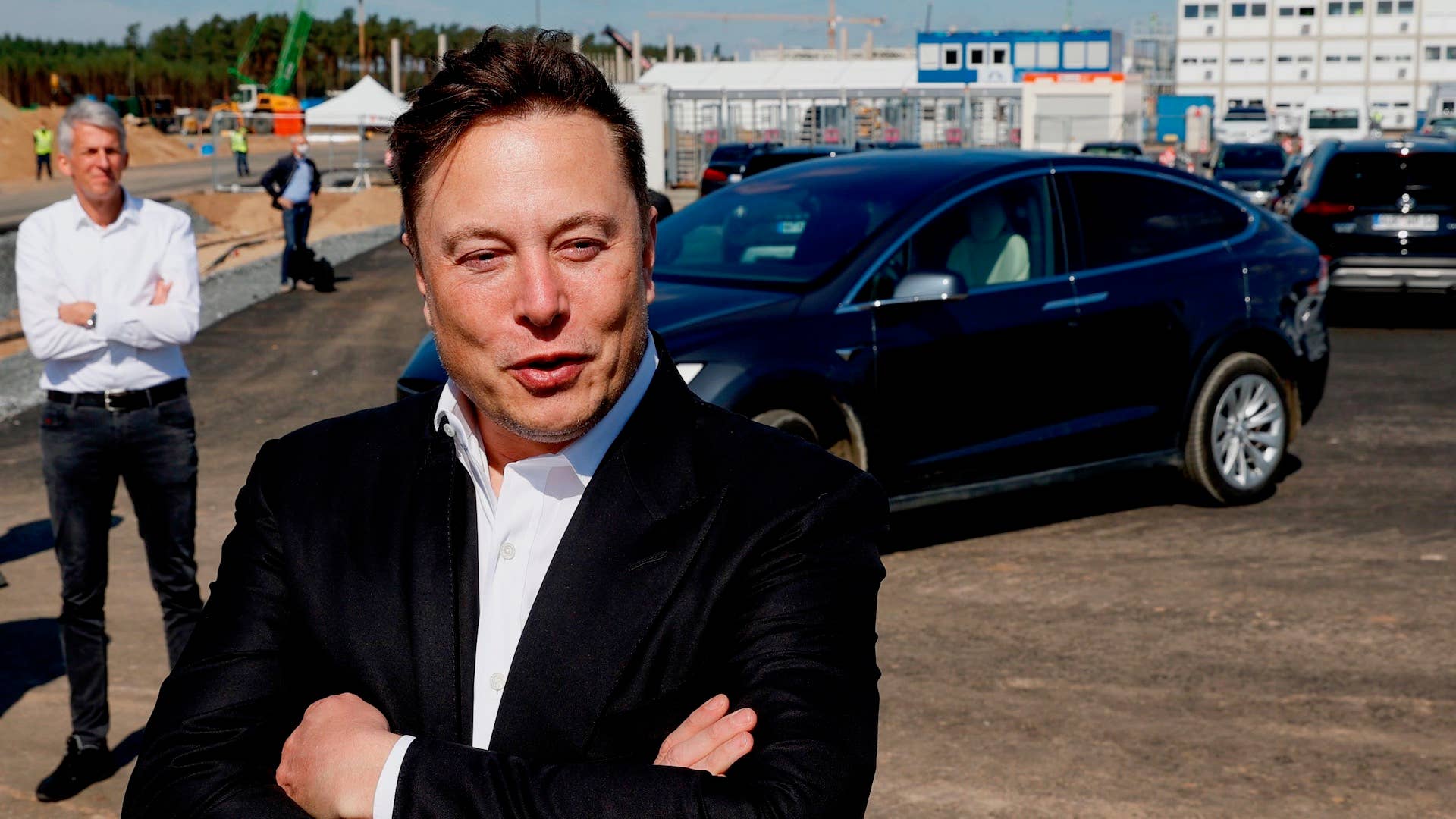 Tesla CEO Elon Musk talks to media as he arrives to visit the construction site of the future US electric car giant Tesla