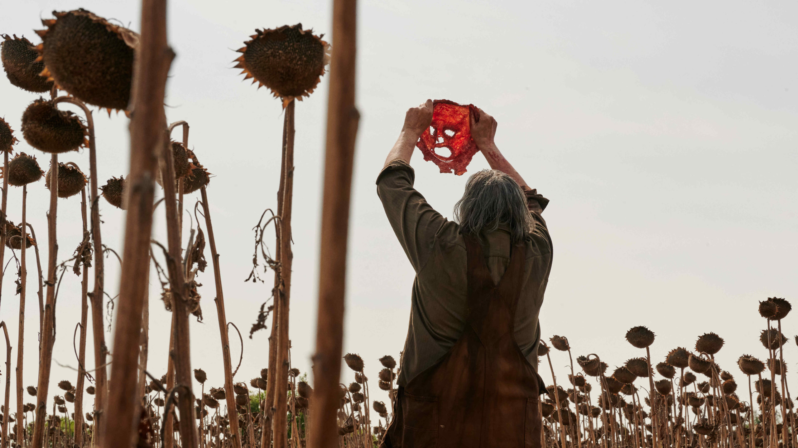 an image of a man holding a face from 2022&#x27;s Texas Chainsaw Massacre