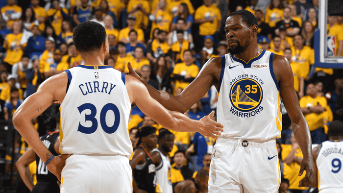 Stephen Curry and Kevin Durant high five while still teammates on Golden State.