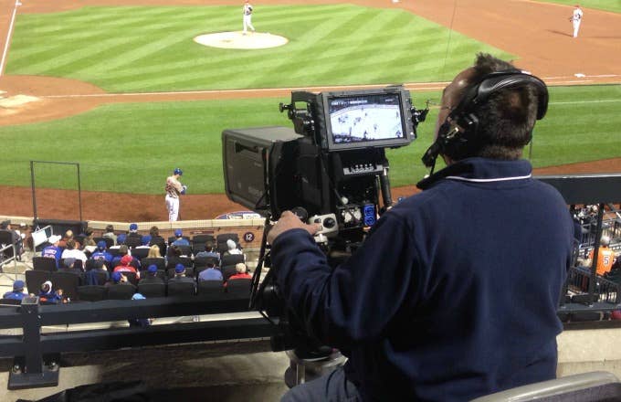 A television cameraman works on the field during the second half