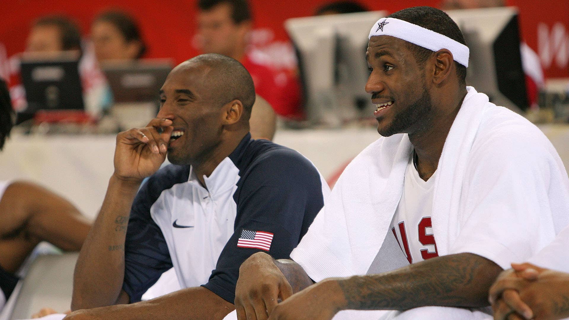 Kobe Bryant #10 and Lebron James #6 of the United States share a laugh on the bench.