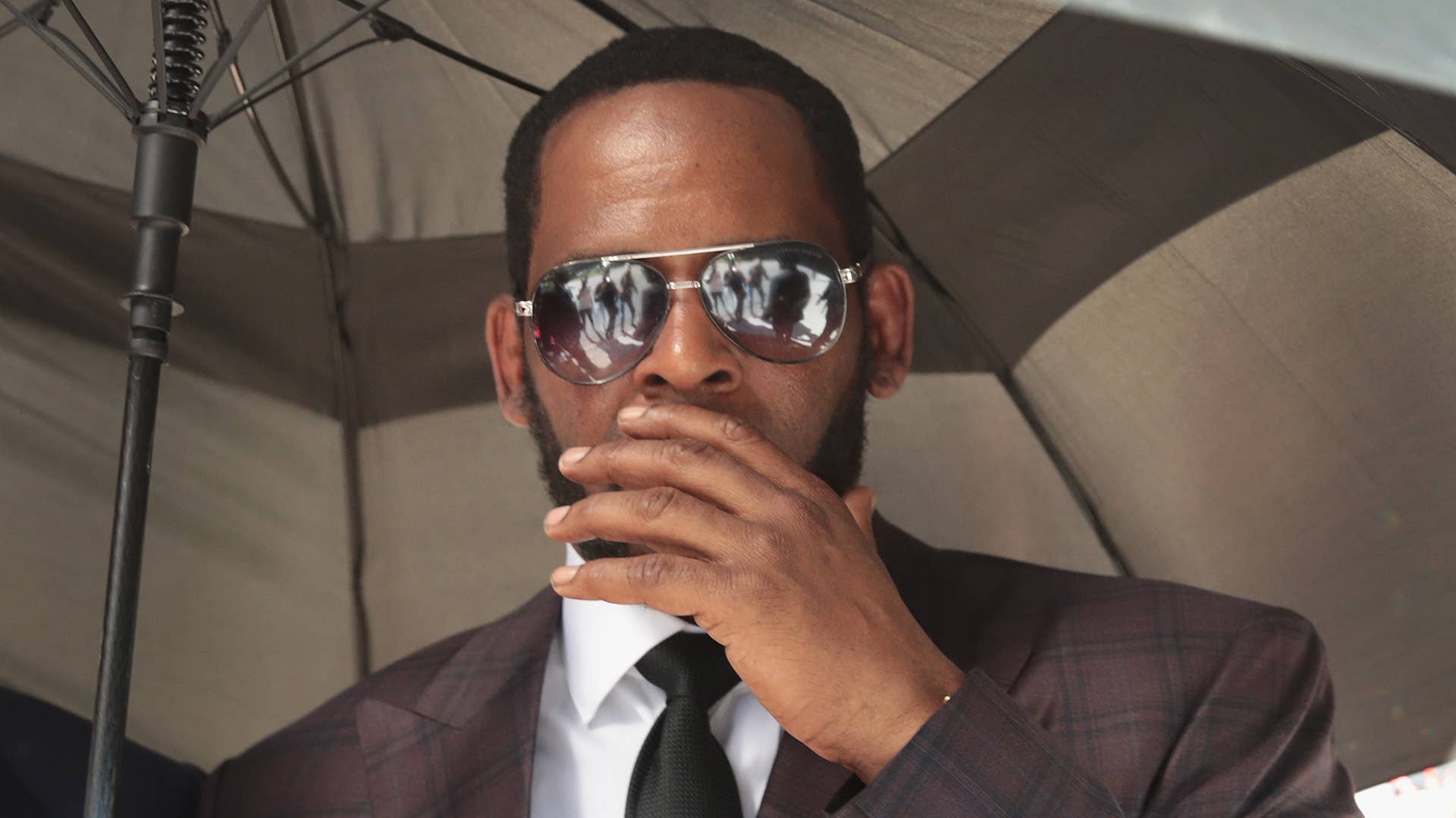 R&B singer R. Kelly covers his mouth