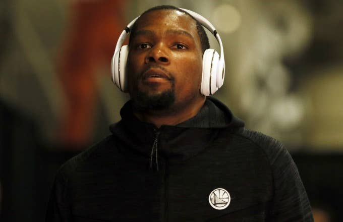 Kevin Durant enters the arena wearing headphones.