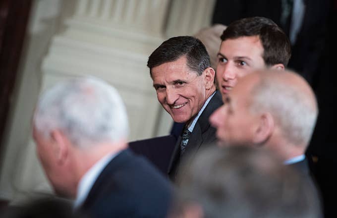 National Security Adviser Michael Flynn talks to others before President Donald Trump