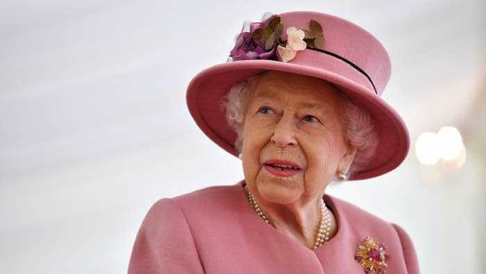 Queen Elizabeth II speaks with staff during a visit.