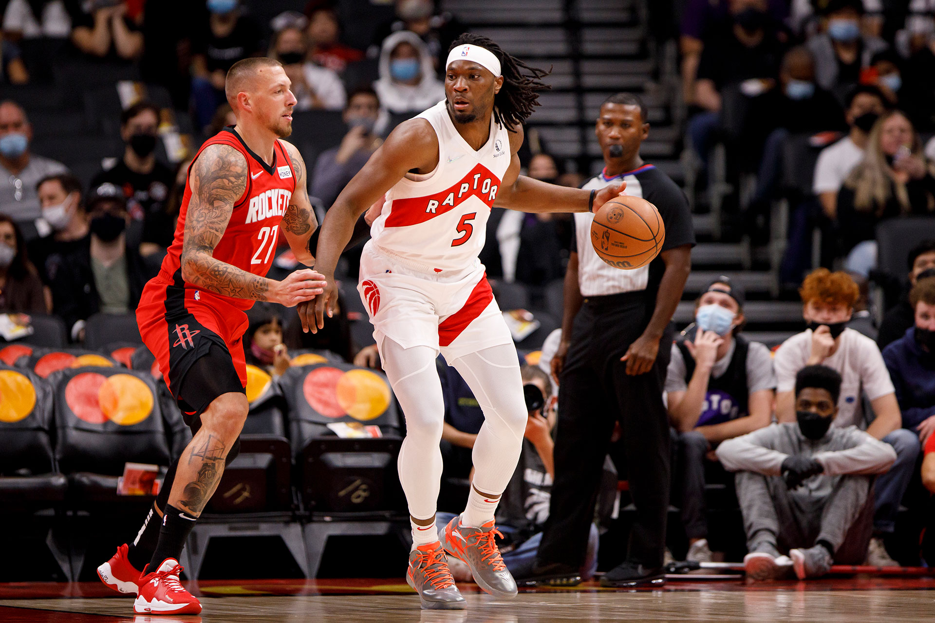 Daniel Theis #27 of the Houston Rockets closely guards Precious Achiuwa #5 of the Toronto Raptors during preseason NBA game