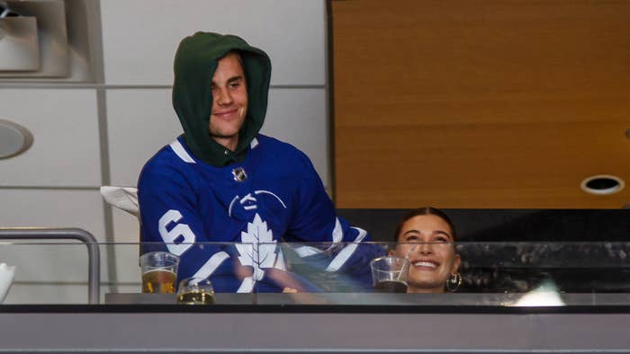 Justin Bieber wearing a Leafs jersey with his wife Hailey Bieber