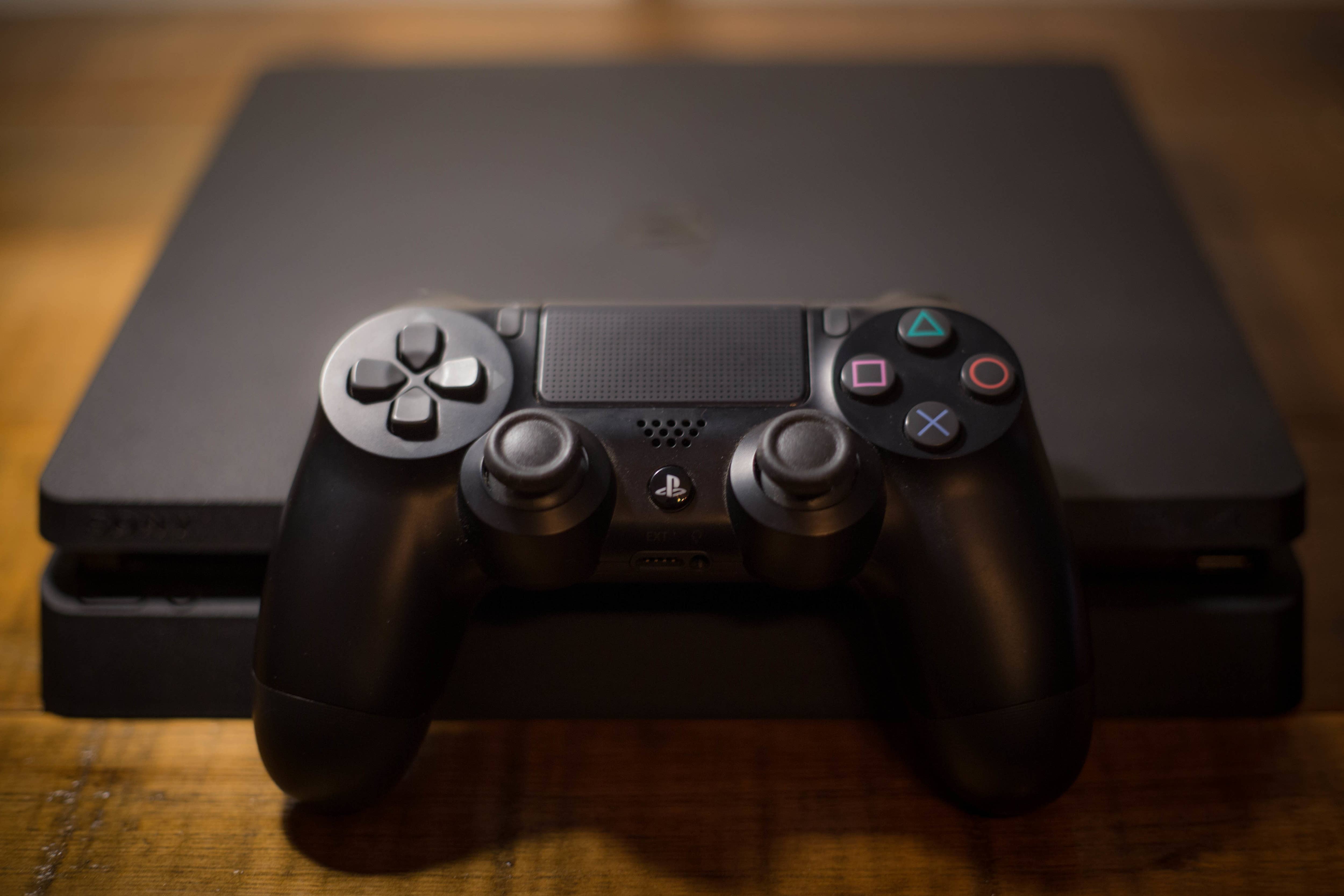 A Sony PlayStation 4 video game console with a black wireless controller