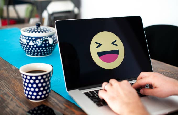 A laptop with a happy emoji face displayed
