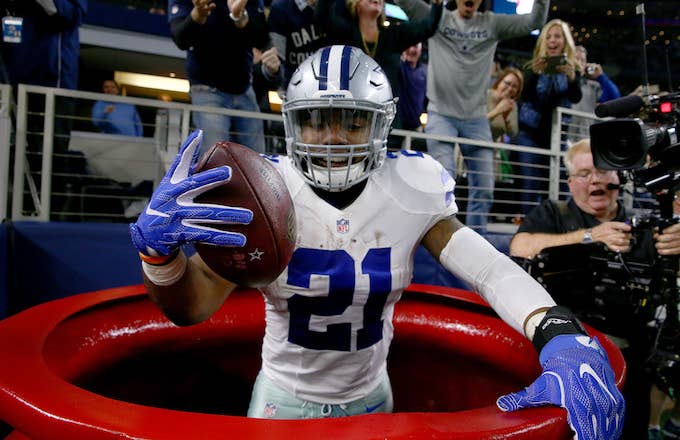 Ezekiel Elliott celebrates after scoring a touchdown by jumping into a Salvation Army red kettle .