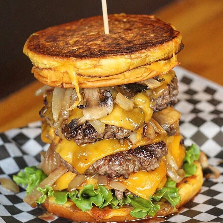 A tall hamburger with mushrooms