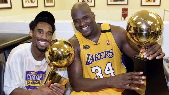 Kobe Bryant holds Larry O&#x27;Brien trophy as Shaq clutches the MVP trophy.